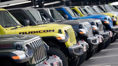 Unsold 2023 Gladiator pickup trucks sit in a long row at a Jeep dealership Sunday, June 18, 2023, in Englewood, Colo.