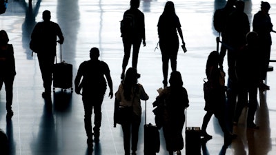 Travelers pass through Salt Lake City International Airport, June 27, 2022.