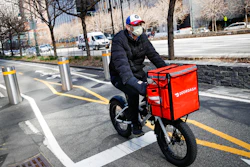 A delivery worker rides his bicycle along a path on the West Side Highway in New York, March 16, 2020.