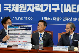 Opposition lawmaker Woo Won-shik, left, shows a list of proposed disposal methods for contaminated water at the National Assembly in Seoul, July 9, 2023.