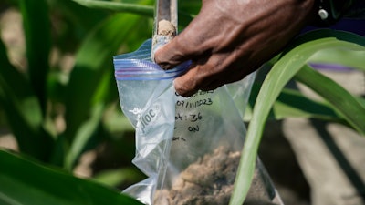 Jude Addo-Chidie, a Ph.D. student in agronomy at Purdue University, places a soil sample into a bag for lab analysis, Butlerville, Ind., July 12, 2023.