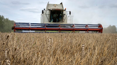 A harvester collects wheat at a farm in Zghurivka, Ukraine, Aug. 9, 2022.