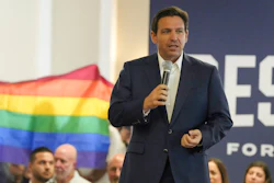 Protesters unfold and raise a rainbow flag behind Republican presidential candidate Florida Gov. Ron DeSantis during a campaign event, Tega Cay, S.C., July 17, 2023.
