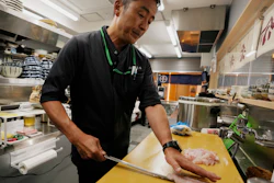 Katsumasa Okawa, owner of a fish store and a restaurant, cuts flounder meat, Iwaki, Japan, July 13, 2023.