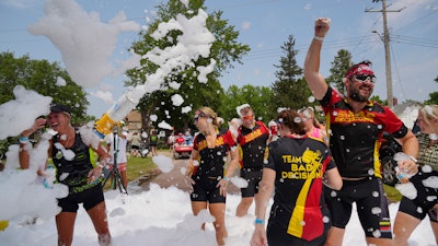 RAGBRAI riders in a foam sprayer in Washta, Iowa, July 23, 2023.
