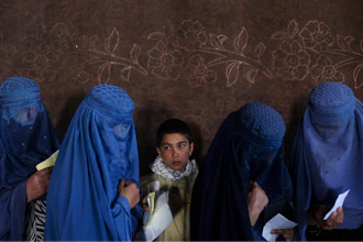 Women wait to receive cash at a money distribution point organized by the World Food Program, Kabul, Afghanistan, Nov. 20, 2021.