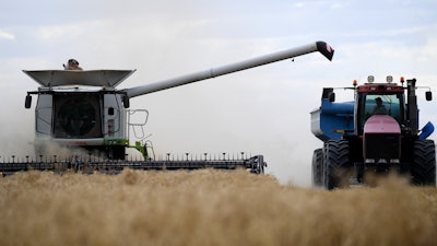 Farm workers harvest a grain crop near Moree, Australia, Nov. 2, 2021.