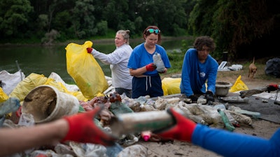 Volunteers sort collected rubbish at a campsite near the Tisza River, Aug. 1, 2023.