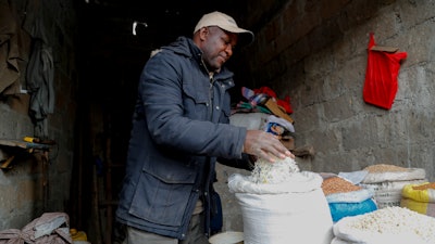 Francis Ndege measures rice at his stall in the Toi Market, Nairobi, Kenya, Aug. 9, 2023.