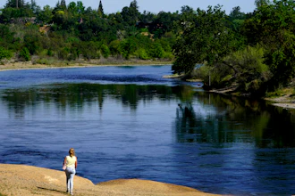 A woman walks along the banks of the American River, Rancho Cordova, Calif., April 8, 2022.