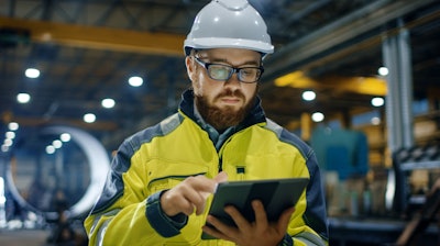 Industrial Engineer In Hard Hat Wearing Safety Jacket Uses Touchscreen Tablet Computer He Works At The Heavy Industry Manufacturing Factory 879814122 5120x2880