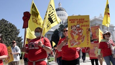 Fast food workers and their supporters march past the California state Capitol in Sacramento, Aug. 16, 2022.