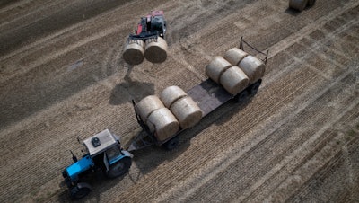 A tractor collects straw on a farm in Zhurivka, Ukraine, Aug. 10, 2023.