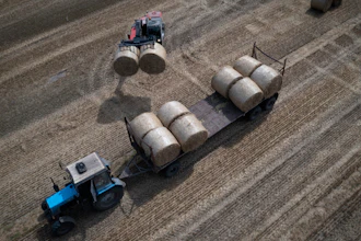A tractor collects straw on a farm in Zhurivka, Ukraine, Thursday, Aug. 10, 2023.