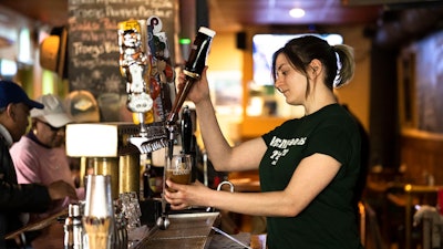A bartender pours a beer at McMenamin's Tavern in Philadelphia, Thursday, Feb. 9, 2023. Despite having great soft skills, workers with a history of food service work may be overlooked as not having relevant experience when it comes to other careers. These workers, however, often have transferable skills that make for excellent employees, particularly in the fast-paced tech environment.