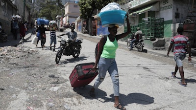Residents flee their homes to escape clashes between armed gangs in the Carrefour-Feuilles district of Port-au-Prince, Haiti, Aug. 25, 2023.