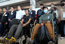 Thai Foreign Minister Parnpree Bahiddha-Nukara, third from left, talks to reporters with injured workers evacuated from Israel, Suvarnabhumi International Airport, Oct. 12, 2023.