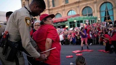 A police officer arrests a member of the Culinary Workers Union along the Strip in Las Vegas, Oct. 25, 2023.