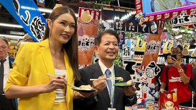 Japanese Agriculture Minister Ichiro Miyashita, right, and Malaysian celebrity Amber Chia attend an event at Japanese store, Don Don Donki in Kuala Lumpur Wednesday, Oct. 4, 2023 to promote the safety and deliciousness of Japanese scallops to shoppers. Japan hopes to resolve the issue of China's ban on its seafood within the scope of the World Trade Organization ambit and will hold food fairs overseas to bolster seafood exports amid safety concerns over the release of treated water from the Fukushima Daiichi nuclear plant, Miyashita said Wednesday.