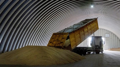 A dump track unloads grain in a granary in the village of Zghurivka, Ukraine, on Aug. 9, 2022. Ukraine, Poland and Lithuania have agreed on a plan they hope will help expedite Ukrainian grain exports, officials said Tuesday, Oct. 3, 2023, with needy countries beyond Europe potentially benefitting from speedier procedures.