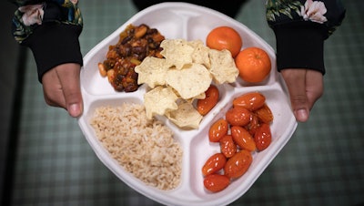 A seventh grader carries her plate during lunch at a public school in Brooklyn, New York, Feb. 10, 2023.