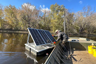 Minnesota DNR Fisheries Technician James Stone works to remove a floating telemetry receiver from the Mississippi River backwaters near La Crosse, Wis., Nov. 6, 2023.