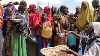 Somalis displaced by drought receive food at makeshift camps outside Mogadishu, March 30, 2017.