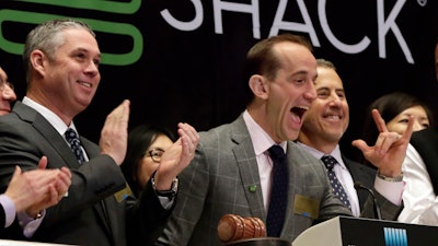 Shake Shack CEO Randy Garutti, center, celebrates during opening bell ceremonies at the New York Stock Exchange, Jan. 14, 2016.