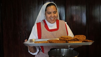 Nun Maria de Jesus Frayle, 24, holds a tray with fried Christmas figures at the Mothers Perpetual Adorers of the Blessed Sacrament convent, Mexico City, Dec. 7, 2023