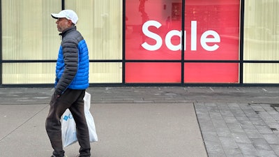 A shopper passes a clothing store in the Thornton Premium Outlets, Thornton, Colo., Dec. 18, 2023.