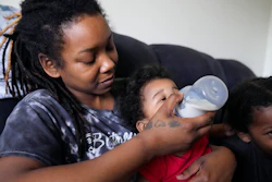 Ashley Yancey feeds her 11 month-old daughter Olivia as two-year old Oliver Tolvert looks on at right, Douglasville, Ga., Dec. 14, 2023.