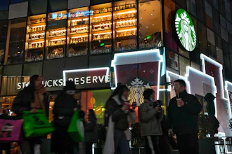 Shoppers walk by a Starbucks cafe at an outdoor shopping mall in Beijing, Dec. 23, 2023.