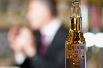 A bottle of Corona Cero beer with Anheuser-Busch InBev CEO Michel Doukeris speaking in the background, London, Jan. 12, 2024.