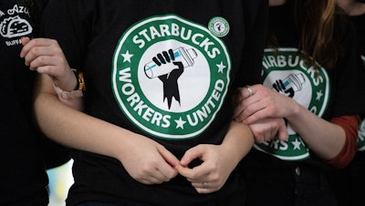 Starbucks employees and supporters link arms during a union election watch party, Dec. 9, 2021, Buffalo, N.Y.