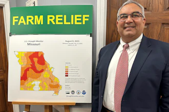 Missouri Treasurer Vivek Malek stands near a poster promoting drought conditions and state aid programs at his Capitol office in Jefferson City, Jan. 4, 2024.