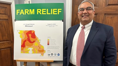 Missouri Treasurer Vivek Malek stands near a poster promoting drought conditions and state aid programs at his Capitol office in Jefferson City, Jan. 4, 2024.