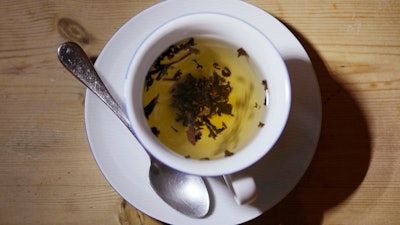 A cup of black tea with a spoon and tea leaves, London, Aug. 29, 2022.