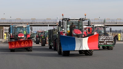 Farmers drive their tractors on a highway leading to Paris near Chamant, France, Jan. 29, 2024.