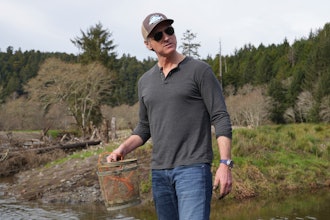 California Gov. Gavin Newsom holds fish trap while touring a salmon restoration project in Redwoods National Park, Calif., Jan. 29, 2024.