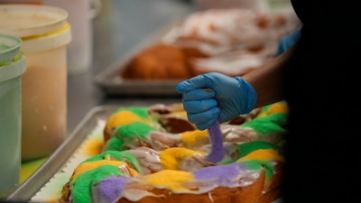Lawren DiBella sprinkles colored sugar onto king cakes at Haydel's Bakery, Jefferson Parish, La., Jan. 31, 2024.