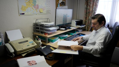 Bart Dochy looks through accounting books at his family farm in Ledegem, Belgium, Feb. 13, 2024.