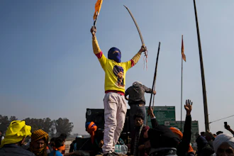 A protester carrying a ceremonial sword shouts slogans as farmers face police near Shambhu, India, Feb.16, 2024.