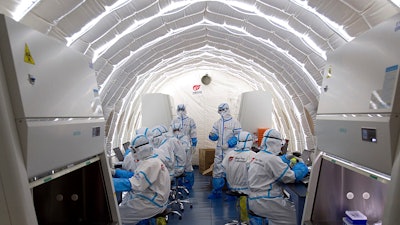 In this file photo released by China's Xinhua News Agency, staff members work in an inflatable COVID-19 testing lab provided by Chinese biotech company BGI Genomics, a subsidiary of BGI Group, in Beijing, June 23, 2020. Members of Congress are raising alarms about what they see as America's failure to compete with China in biotechnology, with risks to U.S. national security and commercial interests.