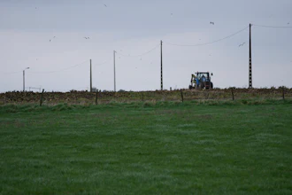 A farmer riding a tractor works in a field in West Flanders, Belgium, Feb. 21, 2024.