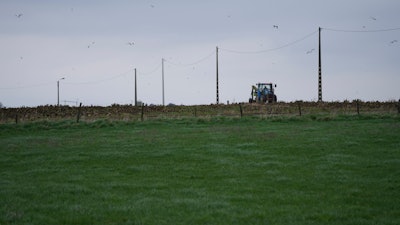 A farmer riding a tractor works in a field in West Flanders, Belgium, Feb. 21, 2024.