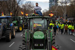 A farmer sits atop a tractor during a protest outside the European Parliament offices in Madrid, Feb. 26, 2024.