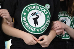 Starbucks employees and supporters link arms during a union election watch party, Buffalo, N.Y., Dec. 9, 2021.