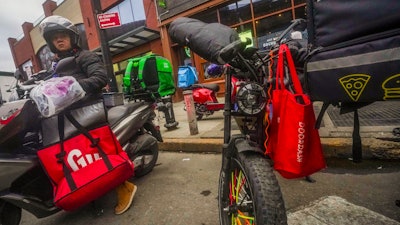 A food delivery worker prepares to ride off from a fast-food restaurant on Brooklyn's Flatbush Avenue, Jan. 29, 2024.