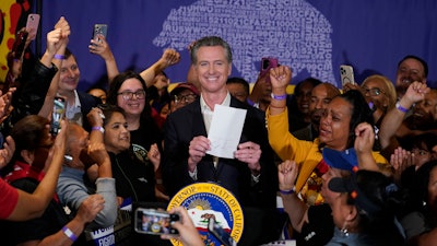 California Gov. Gavin Newsom surrounded by fast food workers at SEIU Local 721, Los Angeles, Sept. 28, 2023.