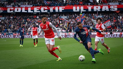 PSG's Kylian Mbappe, right, and Reims' Amir Richardson fight for the ball during a match between Paris Saint-Germain and Reims at the Parc des Princes stadium, Paris, France, March 10, 2024.